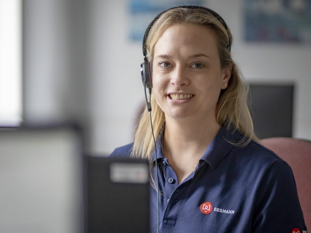 Sympathetic woman with headset in front of computer