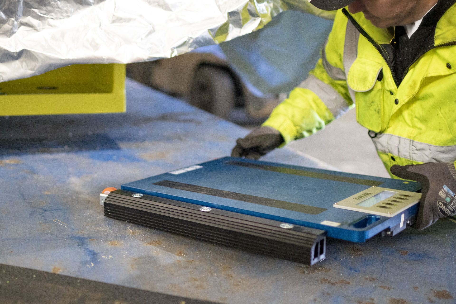 Arbeiter platziert Wägeplattform unter Last