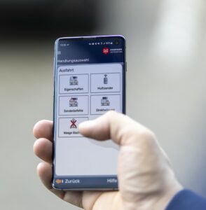 Hand holds smartphone with automated app interface