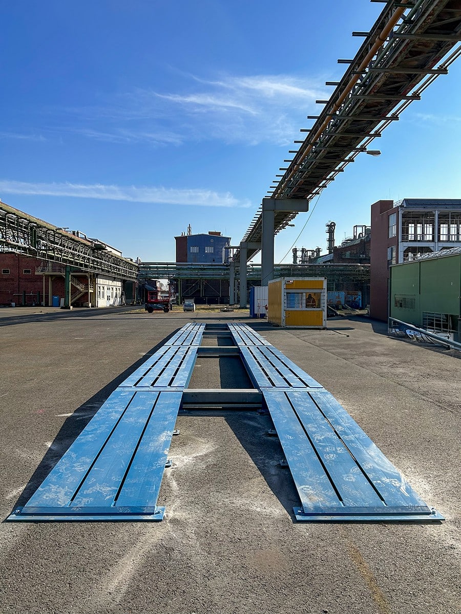 Blauwe stalen weegschalen in industriële buitenruimte
