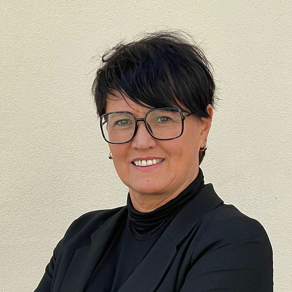 Woman with glasses and black outfit smiles