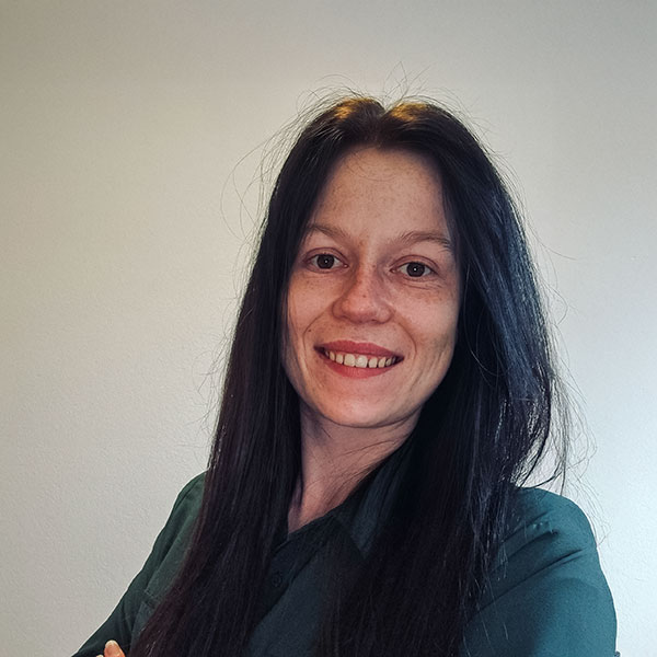 Woman with long dark hair smiles friendly